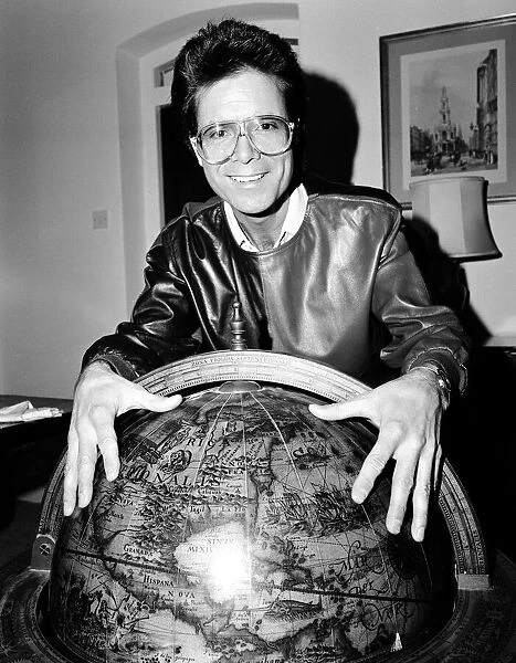 Cliff Richard with a globe. 5th January 1984