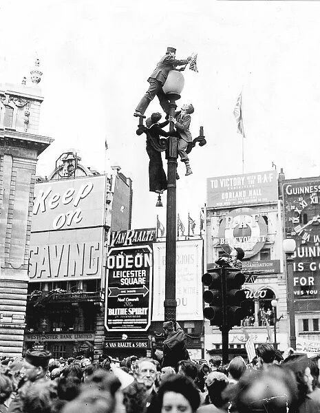 Climbing a lamppost in Piccadilly Circus London to get a better view of the VE-Day
