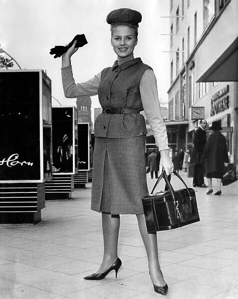 Clothing 1963. Woman wearing a tweed jacket and skirt with handbag and gloves