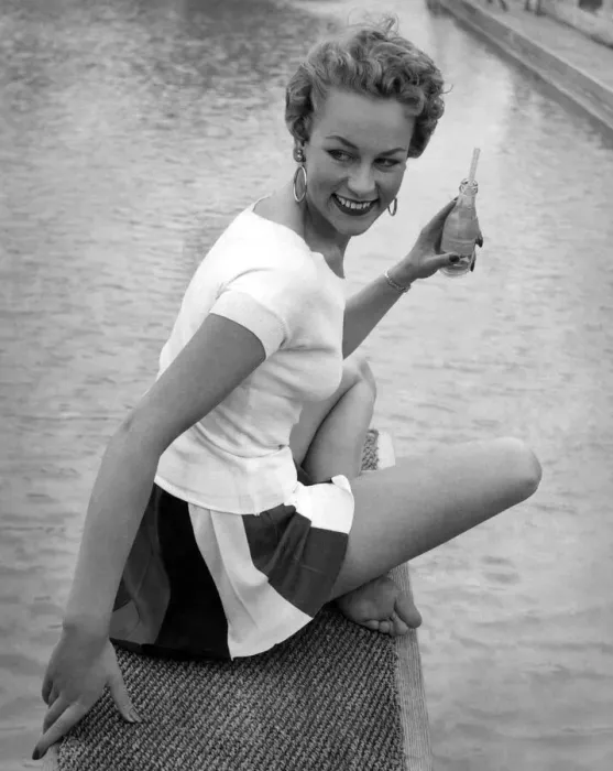 Framed Print : Clothing Beach. Model sits by the water with a drink wearing white t-shirt Framed Print : Clothing Beach. Model sits by the water with a drink wearing white t-shirt