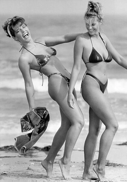 Clothing Beachwear. Two women model bikinis on the sand by the sea