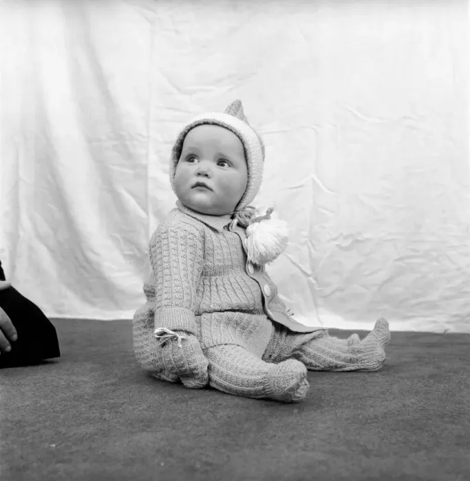 Framed Print : Clothing: Children: Babies: Baby wearing a knitted suit with matching hood and mittens