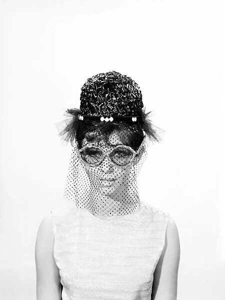 Clothing: Fashion: Hats: Woman wearing hats with veils and glasses. 1962 B1544-033