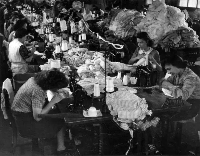 Framed Print : Clothing Industry: Girls at work sewing sleeves on to shirt in the sewing department Framed Print : Clothing Industry: Girls at work sewing sleeves on to shirt in the sewing department
