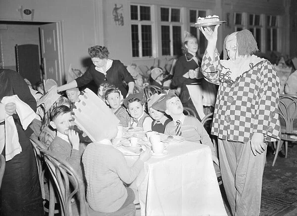 A clown helps out the waitresses at the yearly Daily Mirror Christmas Childrens Party