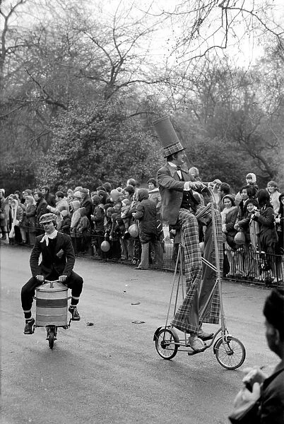 A clown stilt walker seen here riding a oversize bicycle in the Easter parade