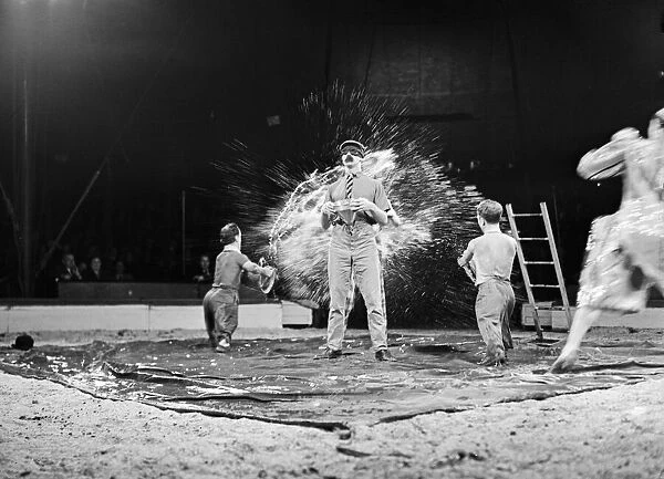 Clowns, clowning about in the the ring during a performance of the Bertram Mills Circus