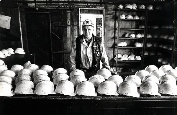 Coal - Miners - Coal miner checks the miners hats at a South Wales Colliery