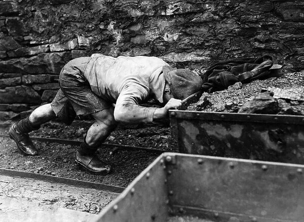 Coal Miners underground scenes. A miner pushing a cart loaded with coal along the track