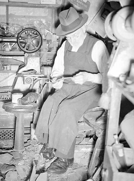A cobbler working in his workshop. circa 1930