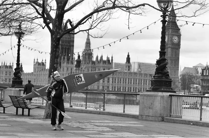 Framed Print : Competitor in the Thames canoe race walks with his boat along the South Bank before Framed Print : Competitor in the Thames canoe race walks with his boat along the South Bank before