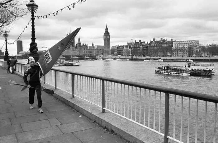 Framed Print : Competitor in the Thames canoe race walks with his boat along the South Bank before Framed Print : Competitor in the Thames canoe race walks with his boat along the South Bank before