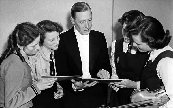 Conductor Stanley Adams (centre) explains a difficult passage to soloists who took part