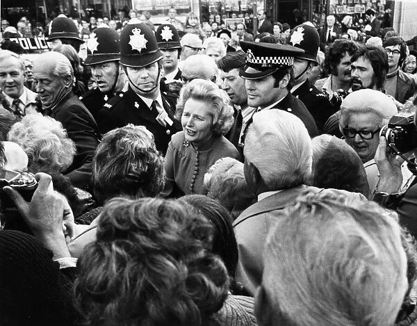 Conservative Party leader Margaret Thatcher surrounded by large crowds as she leaves