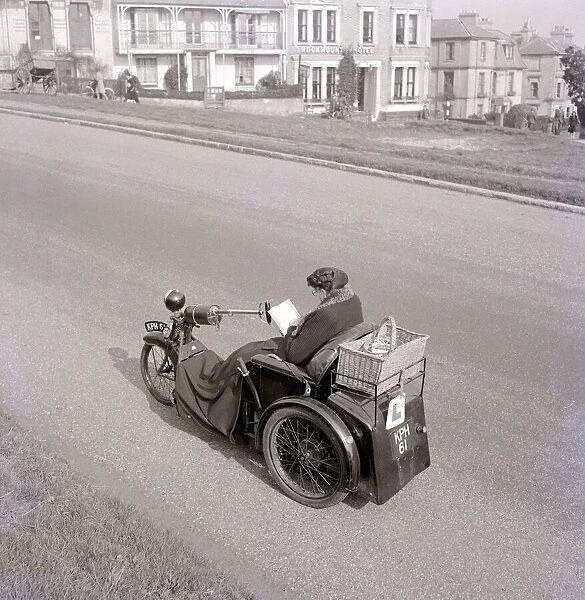 A converted motorbike turned into a three wheeled cab with whicker basket attachment