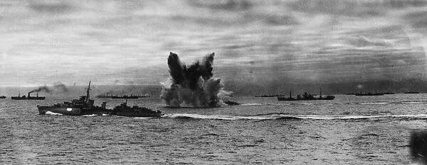 Convoy PQ 18 at sea. An underwater detonation erupts next to HMS Ashanti
