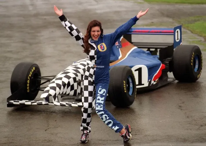 Framed Print : Coping with the wind and rain, model Kelly Brook is pictured with Fosters Formula One car Framed Print : Coping with the wind and rain, model Kelly Brook is pictured with Fosters Formula One car