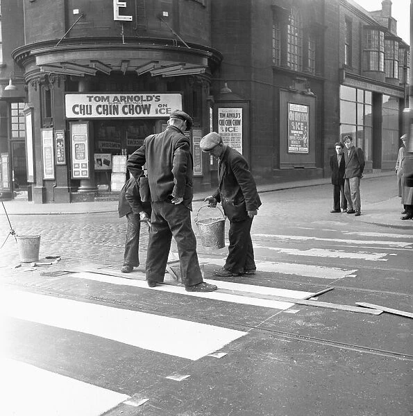 Council workers re-painting a worn out zebra crossing on High Street West