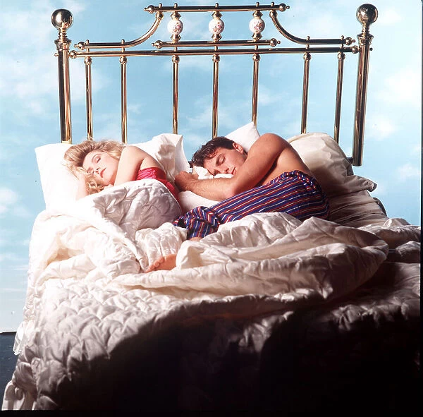 Couple asleep in four poster bed