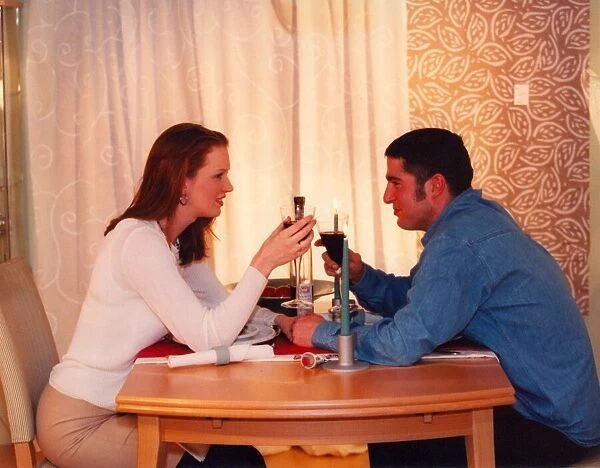 A couple enjoy a romantic candlelit dinner at home