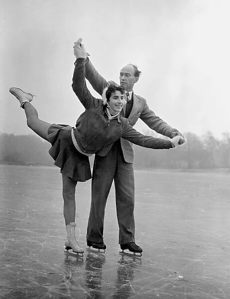 A couple ice skating on a frozen lake in winter January 1954