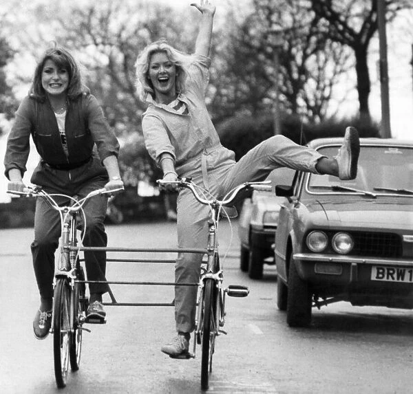 Couple of young ladies on a bicycle made for two, January 1981