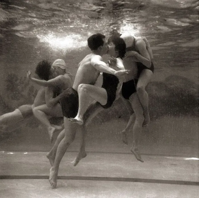 Framed Print : Couples searching for privacy beneath the waters of the swimming pool steal a shy kiss