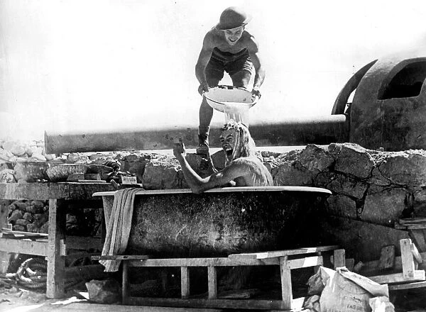 One of the crew of the coastal defence guns in Tobruk, takes a bath under the shadow of