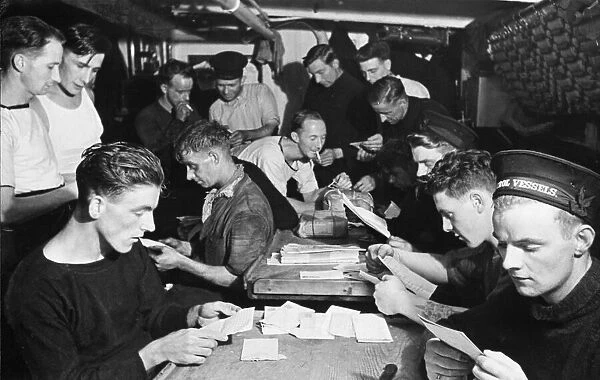 Some of the crew of HMS Minesweeper Commiles, adopted by the Daily Mirror reading their