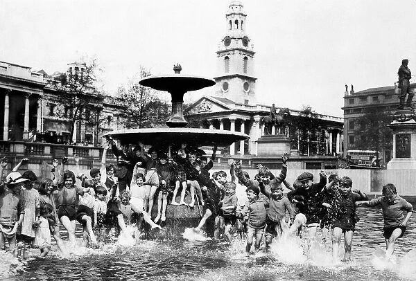 A crowd of children cool off in one of the fountains in Trafalgar Square during