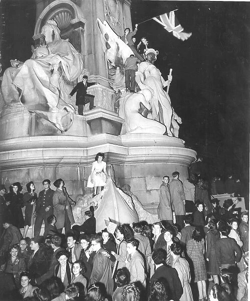 Crowd gathers on a statue in Trafalgar Square London 1945 on VE night
