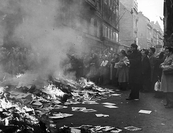 A crowd of Hungarians watch books and pamphlets from a ransacked Russian bookshop being