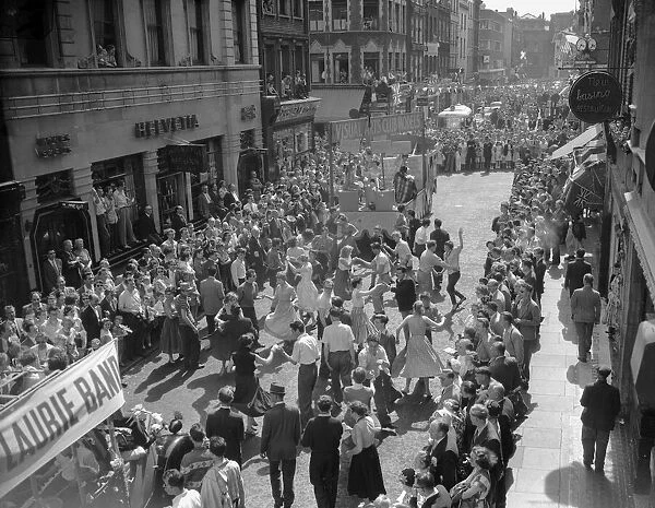 Crowds dancing in the street during the Soho Fair in Central London. 10th July 1955