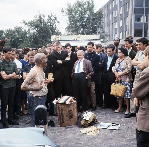 Crowds gather round to hear one of the Tower Hill characters speaking at lunch time, 1966