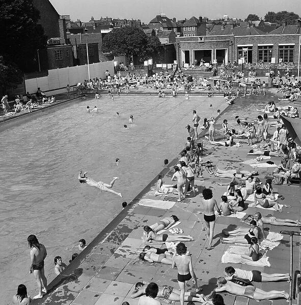 Crowds of sunbathers at the Twickenham outdoor swimming pool, London. 7th June 1975