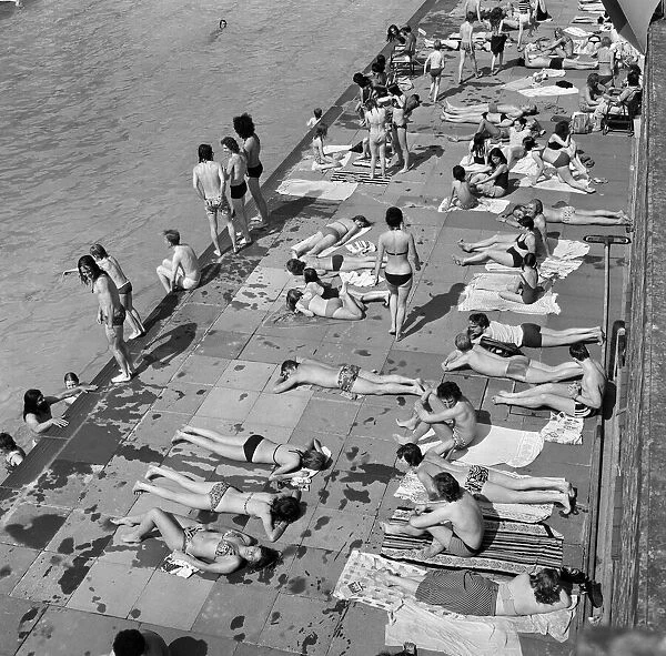 Crowds of sunbathers at the Twickenham outdoor swimming pool. London, 7th June 1975