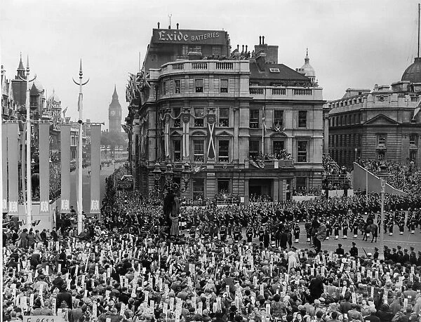Crowds in Trafalgar Square watch the military procession march past as they make their