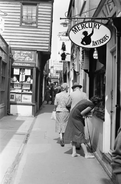Framed Print : A customer looking through the window of antique dealers shop in The Lanes in Brighton