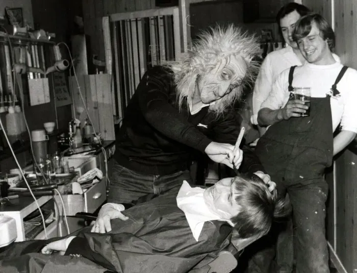 Framed Print : A customer sits in the barbers chair having his faced shaved by a man in a mask at Steve