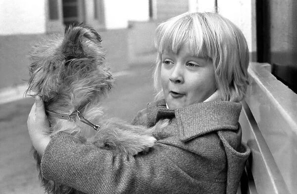 Cute children and Animals: Young girl holding her puppy dog. January 1980 80-00007-001