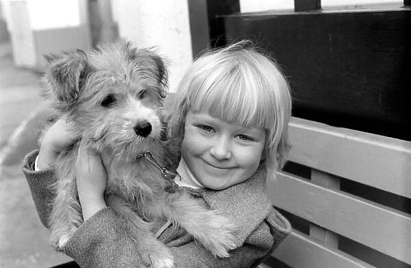 Cute children and Animals: Young girl holding her puppy dog. January 1980 80-00007-002