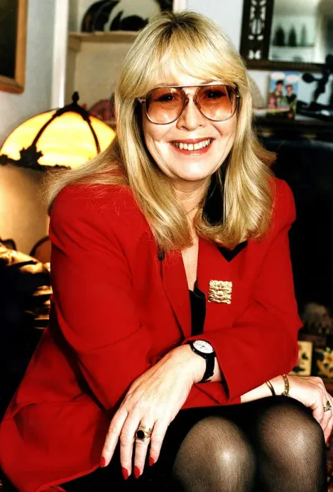 Framed Print : Cynthia Lennon wearing red jacket with arms on knees and dark glasses December 1995 Framed Print : Cynthia Lennon wearing red jacket with arms on knees and dark glasses December 1995
