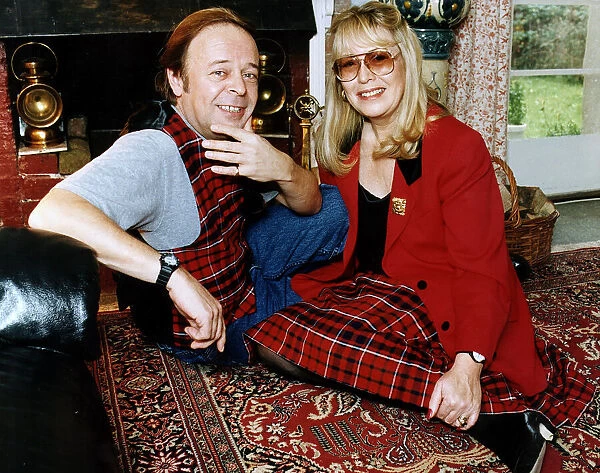 Cynthia Lennon wearing red jacket tartan skirt sitting on the carpet with Jamie Christie