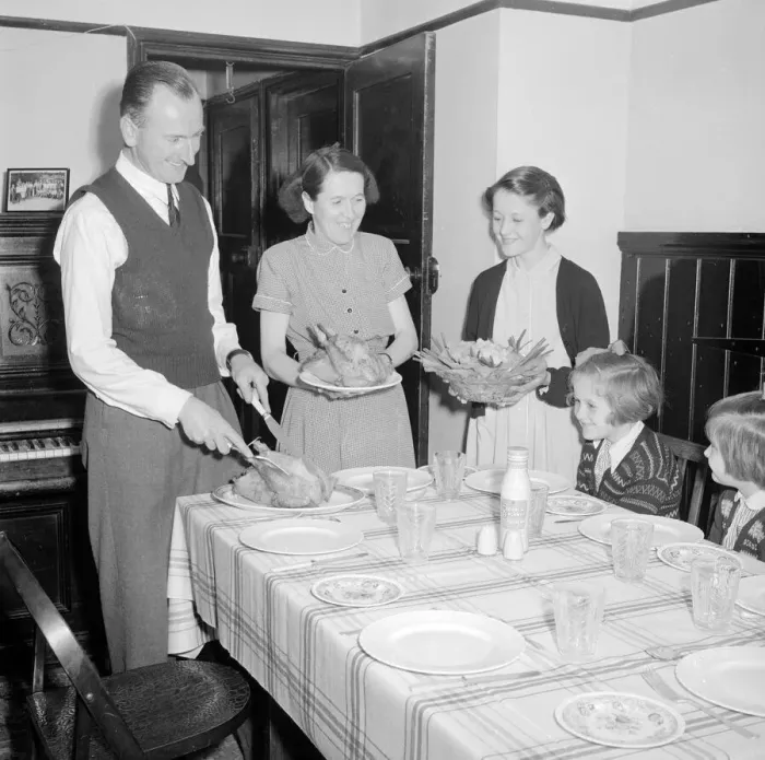 Framed Print : Dad carves the chicken as mum and eldest daughter brings in the vegtables for lunch