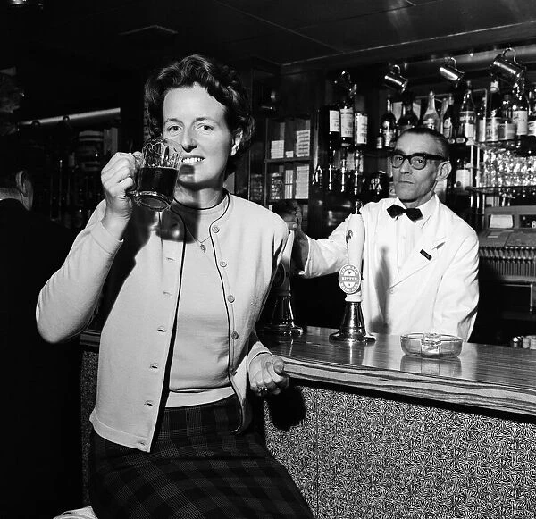 Daily Mirror photographer Doreen Spooner drinking beer for a feature in the Daily Mirror