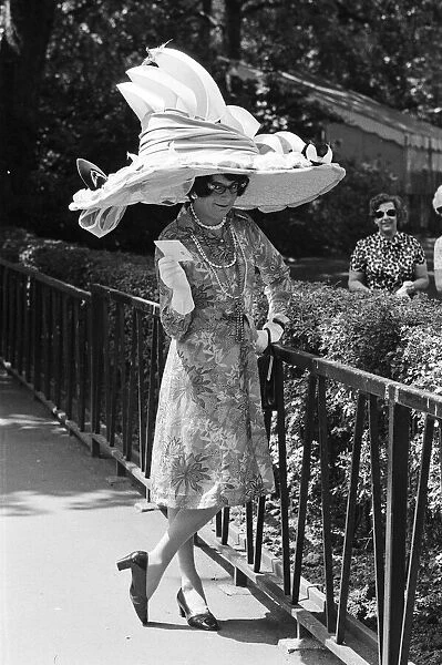 Dame Edna Everage (aka Barry Humphries) trying on her new hat for Ascot