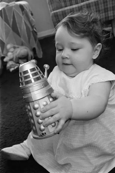 Framed Print : The daughter of Raymond Cusick designer of the Daleks from Doctor Who playing with a toy Framed Print : The daughter of Raymond Cusick designer of the Daleks from Doctor Who playing with a toy