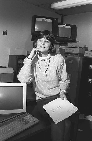 DEBBIE THROWER - TV PRESENTER SITTING ON A DESK WITH COMPUTER AND TV SCREENS - 05  /  01  /  1988