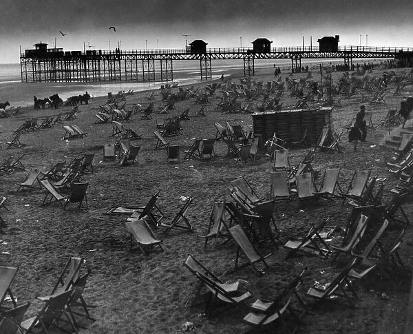 Empty deck chairs sprawl forlornly on the deserted beach at Rhyl after the storm had