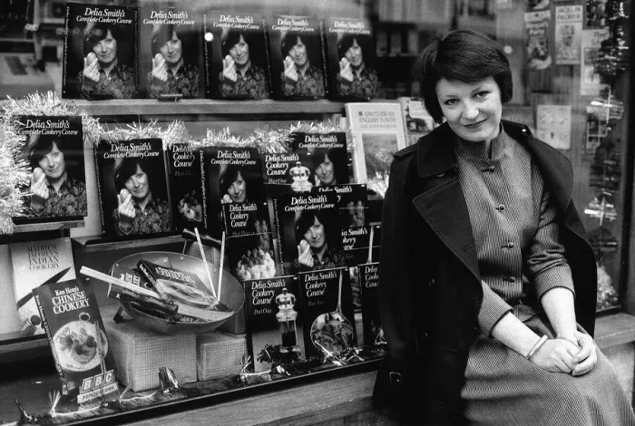 Framed Print : Delia Smith TV Chef and writer sits outside bookshop that has a window full of her books Framed Print : Delia Smith TV Chef and writer sits outside bookshop that has a window full of her books